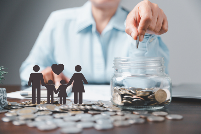 A woman putting coins into a jar, symbolizing protection of family through life insurance.