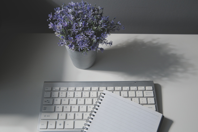 Digital memorial websites depicted purple flowers next to a computer keyboard.