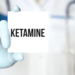 Photo of a doctor holding a ketamine sign referring to use of ketamine therapy for grief.