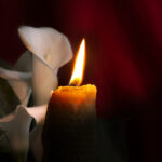 A photo of a flower and candle representing virtual funerals and funeral planning.