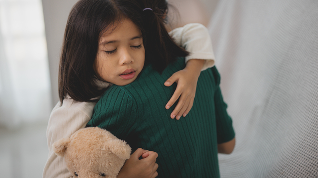 A photo of a girl an a mothers arms symbolizing Helping children grieve.