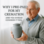 Senior man in cardigan holding cremation urn while smiling peacefully, representing pre-paid cremation planning and end-of-life preparation