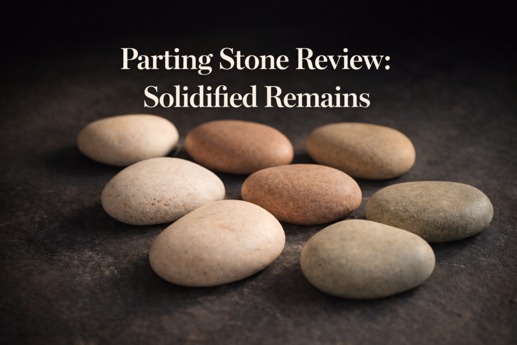 Smooth solidified remains stones in natural earth tones resting on dark charcoal slate surface with warm directional light highlighting unique colors and textures