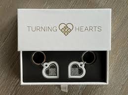 Turning Hearts QR code memorial keychain in white gift box, a separate product that links to the same digital memorial profile as the medallion
